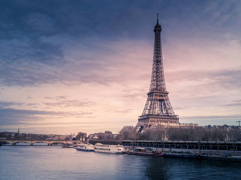The Eiffel Tower above the Seine in Paris at dusk