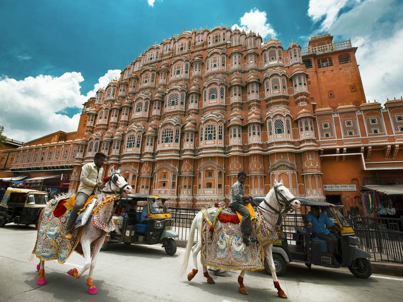 Decorated horses passing Hawa Mahal in Jaipur